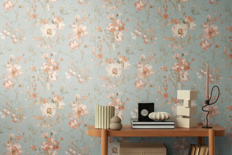 Tapete mit floralem Blumenmuster im Aquarellstil vor einer Konsole mit Dekorationsgegenständen