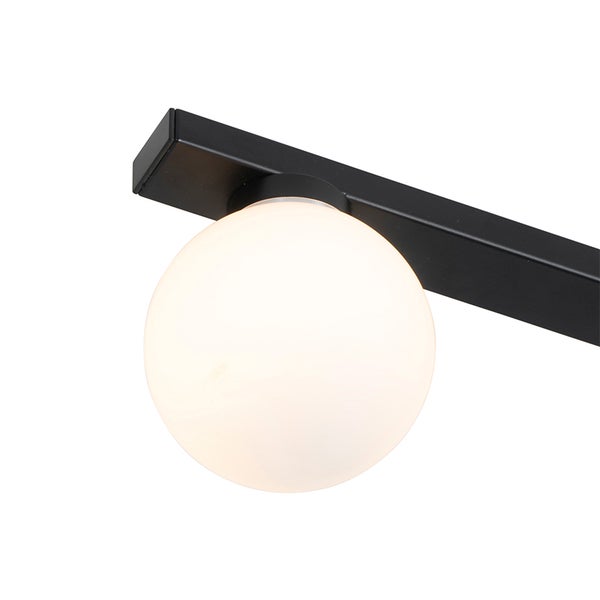 Detailansicht einer modernen Leuchte mit schwarzer Metallstange und weißer Glaskugel.