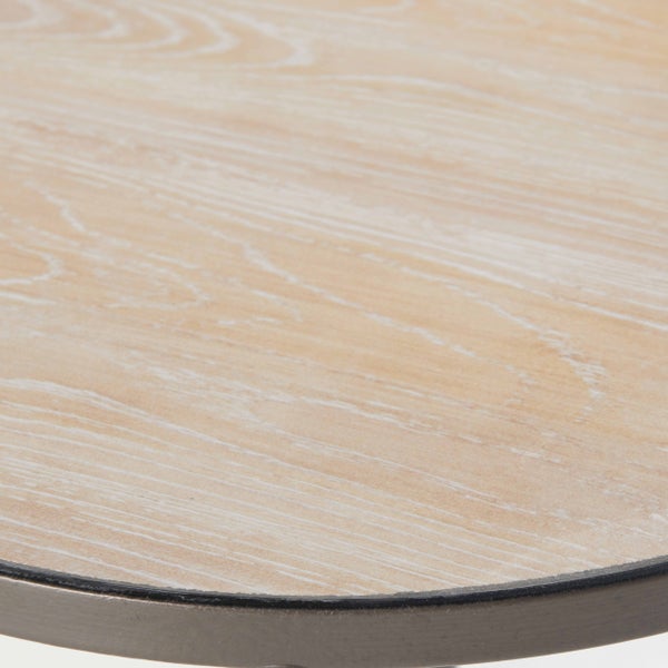 Detailansicht einer runden Tischplatte aus hellem Holz mit sichtbarer Maserung und einer dunklen Metallkante.