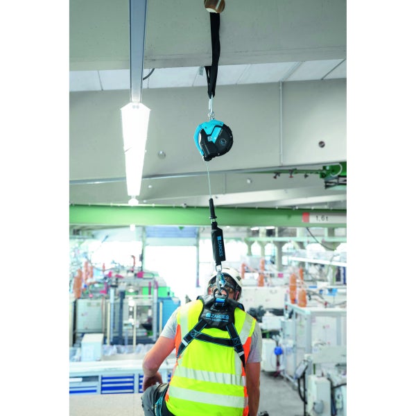 Ein Bauarbeiter mit Sicherheitsgurt und Höhensicherungsgerät bei der Arbeit.