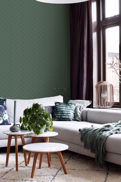 Wohnzimmer mit grüner Tapete in Fischgrätenmusteroptik, Couchtisch und Sofa