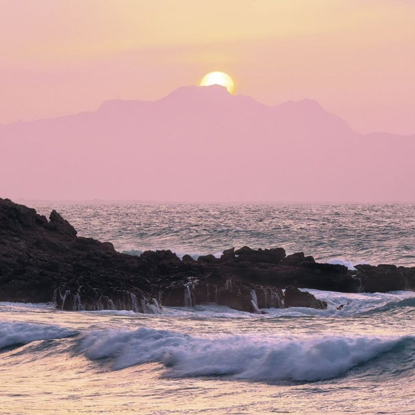 Landschaft mit Meer, Felsen und Sonnenaufgang