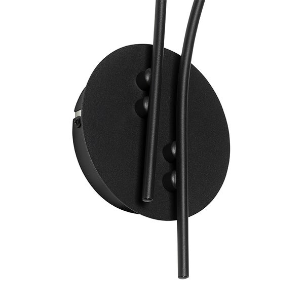 Detailansicht einer Wandleuchte mit rundem Lampenfuß und zwei gebogenen Leuchtenarmen