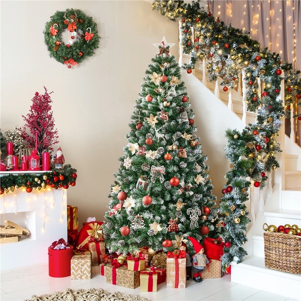 Festlich geschmücktes Wohnzimmer mit Weihnachtsbaum, Treppe und Kamin für eine weihnachtliche Atmosphäre.