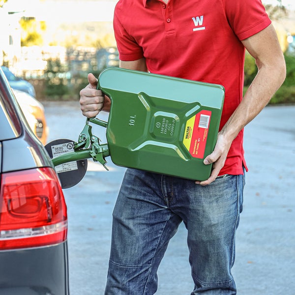 Eine Person befüllt einen Autotank mit einem 10 Liter Walter Benzinkanister mit Trichter