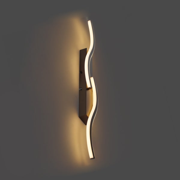 Moderne Wandleuchte mit geschwungenem Design und integrierten LEDs zur indirekten Beleuchtung.