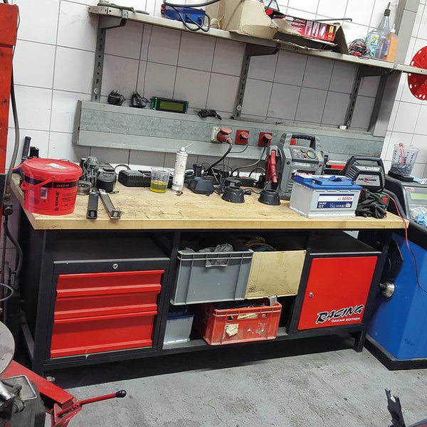 Werkbank mit Autobatterie und Aufbewahrungsboxen