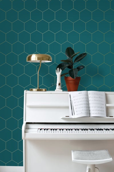 Dekoratives Zimmer mit einer weißen Klaviatur vor einer Wand mit Sechseckmuster
