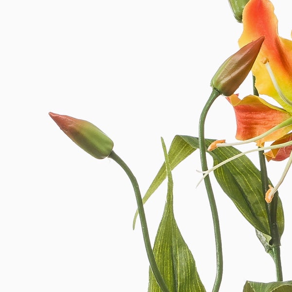 Detailansicht einer künstlichen Lilie Gloriosa mit grünen Blättern und orangefarbenen Blüten.