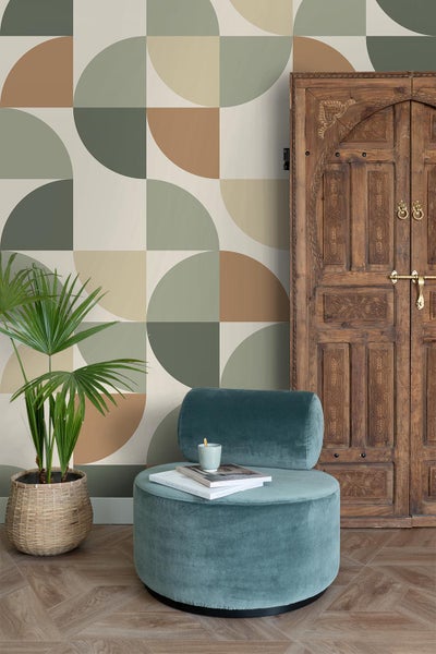 Raumgestaltung mit geometrischer Tapete, Pflanze und einem türkisfarbenen Hocker