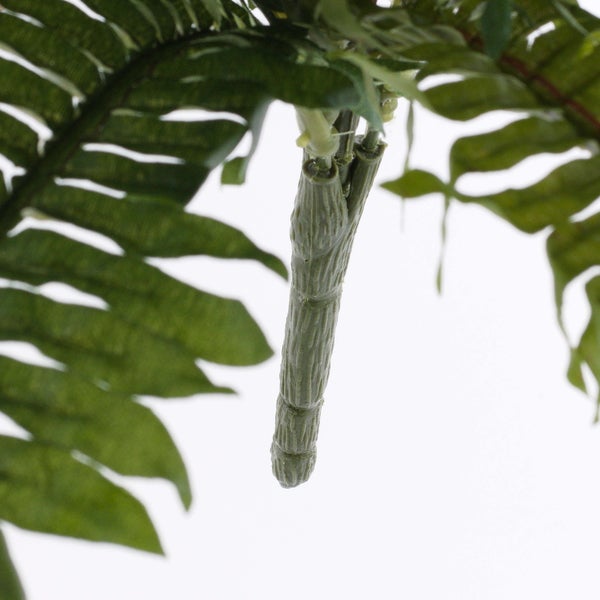 Detailansicht eines künstlichen Farnblatts mit strukturiertem Stiel.