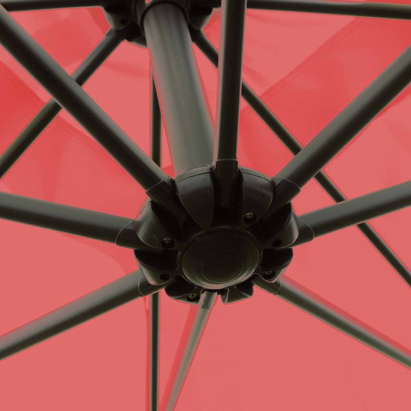 Detailansicht der schwarzen Streben und der Nabe unter einem roten Sonnenschirm.