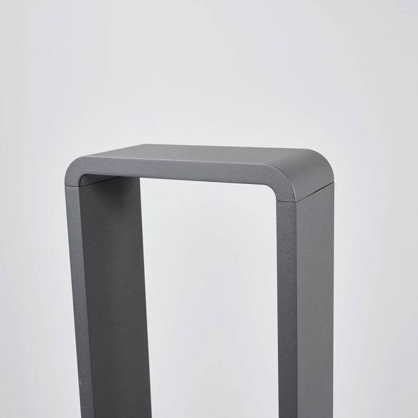 Nahaufnahme einer modernen, u-förmigen Außenleuchte aus anthrazitfarbenem Metall mit abgerundeten Kanten.