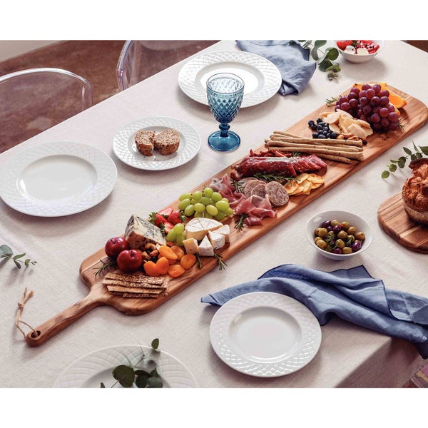 Esstisch gedeckt mit Aufschnittplatte, Geschirr und Getränkeglas