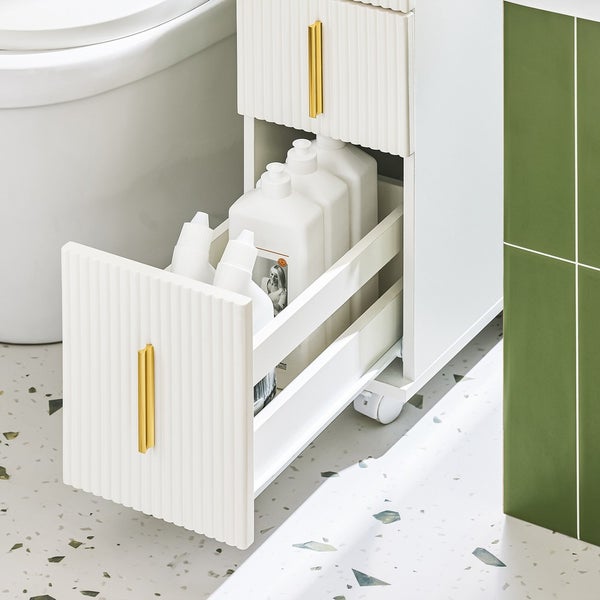 Badezimmer mit einem weißen Unterschrank mit Schublade für Reinigungsutensilien neben einer Toilette
