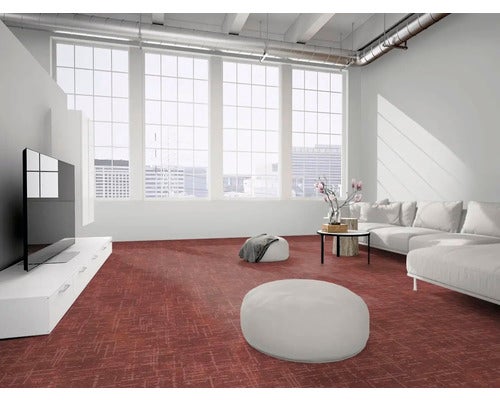 Helles, modernes Wohnzimmer mit großen Fenstern, weißem Sofa und rotem, gemustertem Bodenbelag.