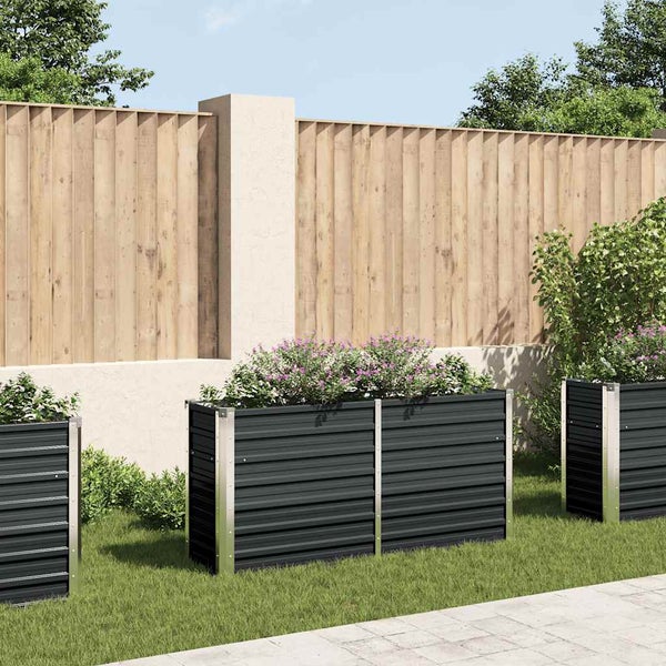 Drei bepflanzte, rechteckige Pflanzkästen aus Metall im Garten.