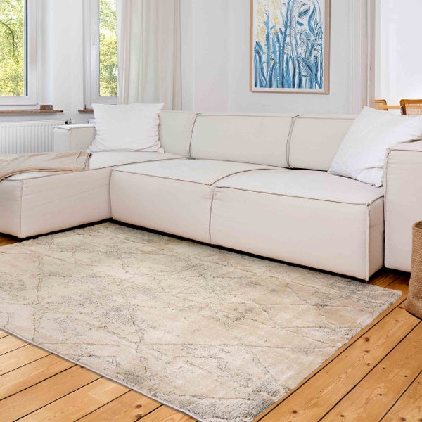 Heller Wohnbereich mit gemustertem Teppich, Sofa und Fenster.