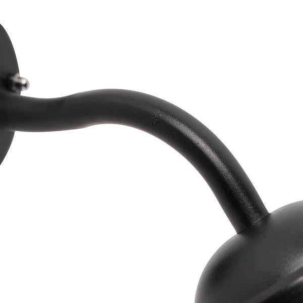 Detail eines geschwungenen Metallarms einer Wandleuchte in Schwarz.