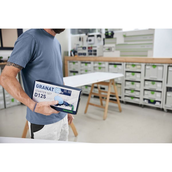 Mann hält Festool Granat Starter Set D125 Schleifscheiben