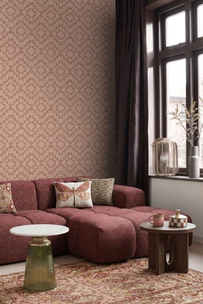 Wohnzimmer mit Vliestapete mit geometrischem Muster, modernem modularem Sofa, Beistelltischen und Fenster mit Vorhängen.