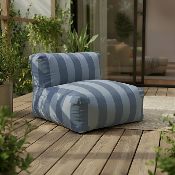 Gestreifter Outdoor-Lounge-Sessel aus Stoff auf einer Holzterrasse mit Pflanzen.