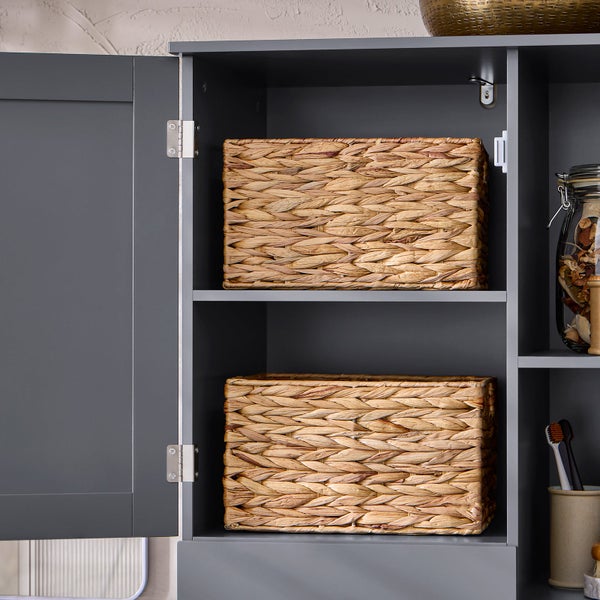 Grauer Badezimmerschrank mit zwei Weidenkörben und einem Vorratsglas