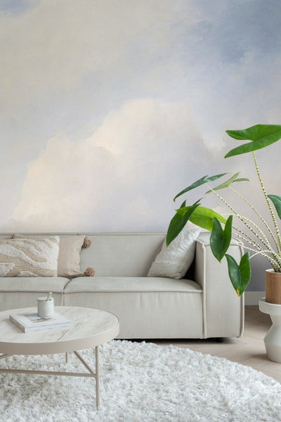 Wohnzimmer mit Sofa, Couchtisch, Teppich und Zimmerpflanze vor einer Wandtapete