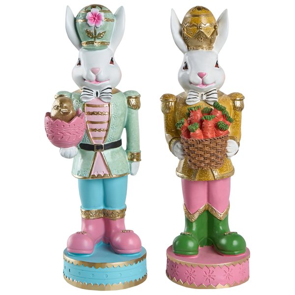 Zwei Osterhasen-Dekofiguren im Nussknacker-Stil, eine Figur mit Ei und Küken, eine Figur mit einem Korb voller Karotten.