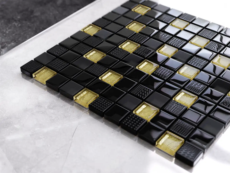 Quadratische Glasmosaikfliesen in Schwarz und Gold mit glatter und strukturierter Oberfläche.