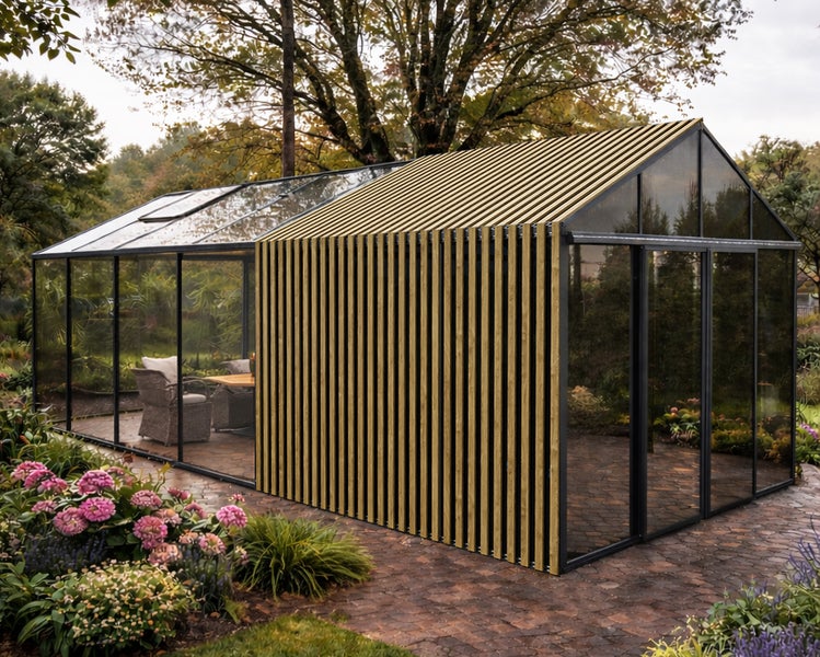 Modernes Gewächshaus aus Glas mit schwarzem Metallrahmen und Holzlamellen, eingerichtet mit Gartenmöbeln auf einer Terrasse aus Stein.