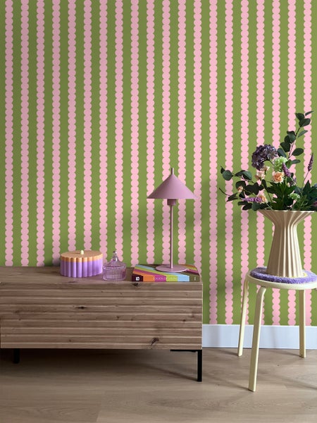 Zimmer mit gemusterter Tapete, Kommode und Blumenarrangement