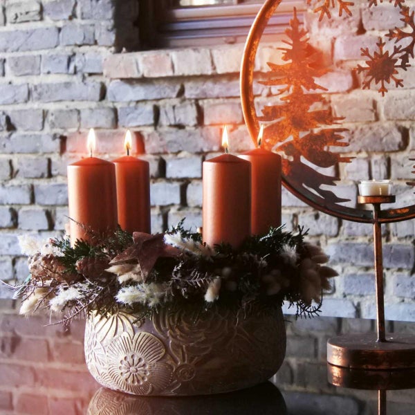 Nahaufnahme der Oberflächenstruktur eines Blumentopfs mit geprägtem Blumenmuster aus Steinzeug.