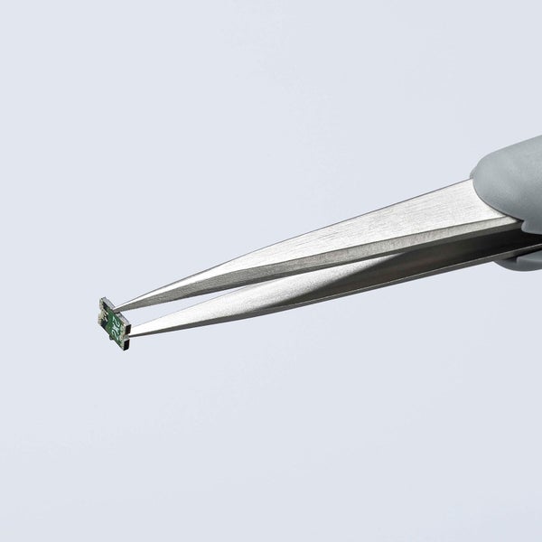 Pinzette hält eine kleine elektronische Komponente