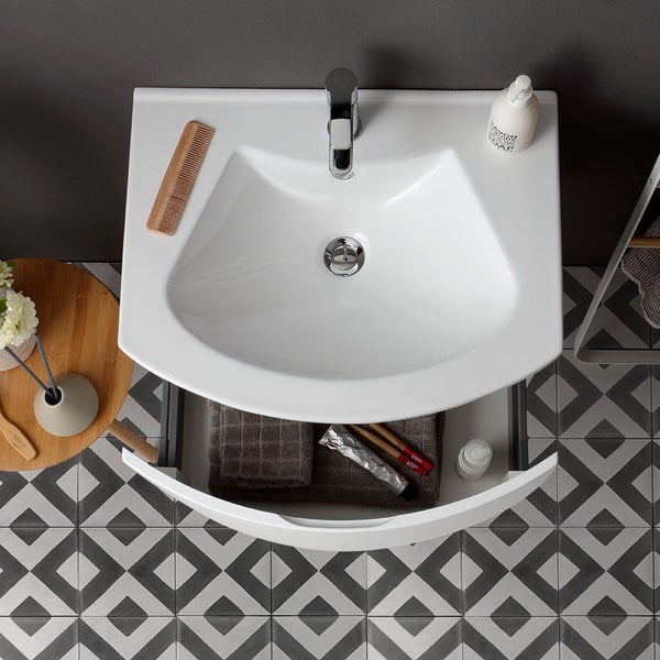 Aufnahme von oben eines Waschbeckens mit Armatur, Holzaccessoires und offenem Unterschrank im Badezimmer