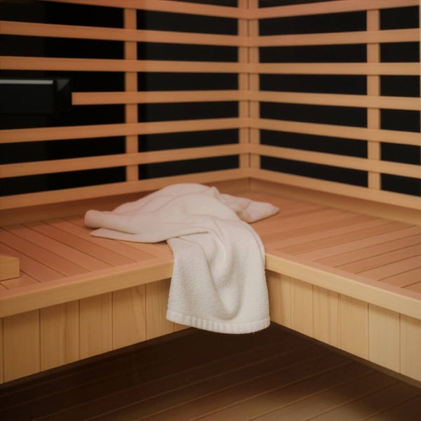 Eine Frau entspannt in einer modernen Home Deluxe Heimsauna mit Holzvertäfelung und indirekter Beleuchtung durch eine Glastür betrachtet.
