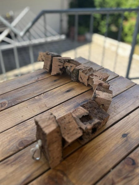 Flexible Brücke aus Naturkork für Kleintiere und Vögel auf einem Holztisch.
