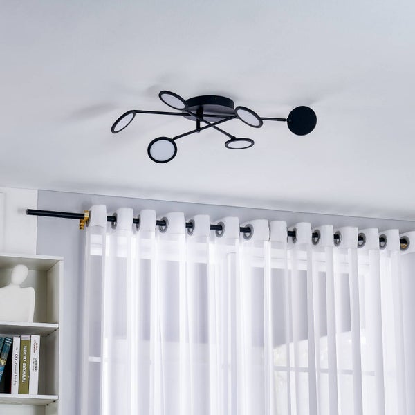 Moderne Deckenleuchte mit kreisförmigen LED-Elementen an schwarzen Armen in einem hellen Raum mit weißem Vorhang.