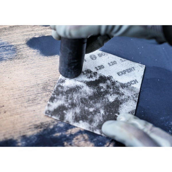 Schleifpapier wird mit einem Schleifklotz auf einer Holzoberfläche verwendet.