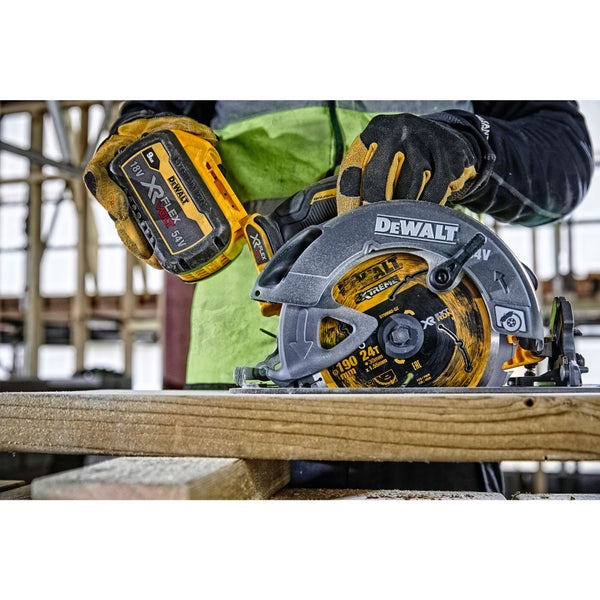 Eine Person setzt eine DeWalt Batterie in eine Handkreissäge ein, die auf einem Holzbrett steht.