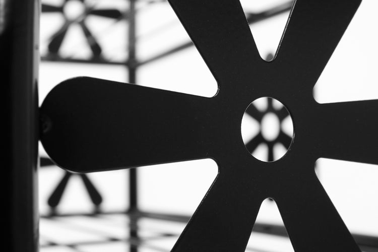 Detailaufnahme eines Metallregals mit dekorativem Ausschnittmuster
