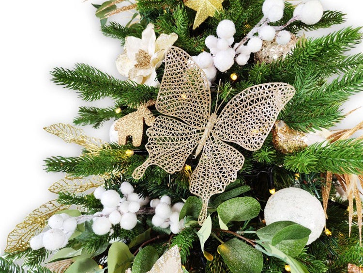Weihnachtsbaumdekoration mit einem Schmetterling, künstlichen Tannenzweigen, weißen Beeren und festlichen Schmuckelementen.