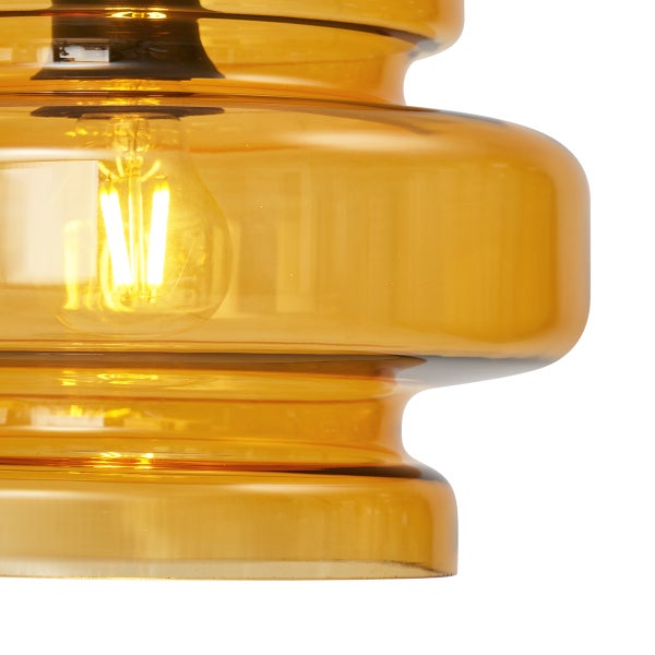 Detailaufnahme einer bernsteinfarbenen Glaspendelleuchte mit Glühbirne