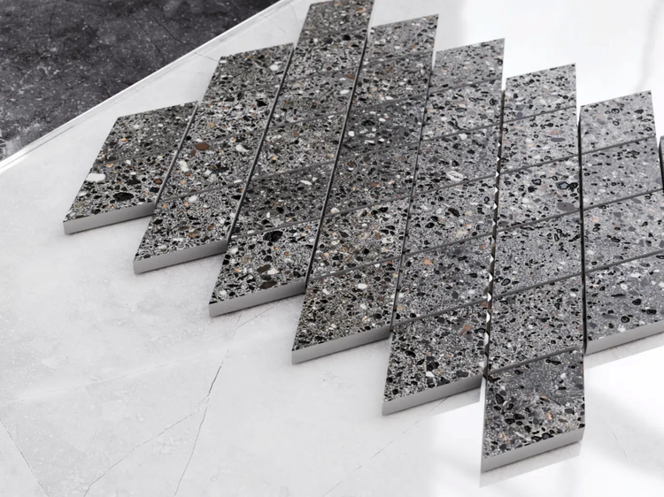 Mosaikfliese in Rautenform mit grauem Terrazzo-Muster aus Feinsteinzeug.