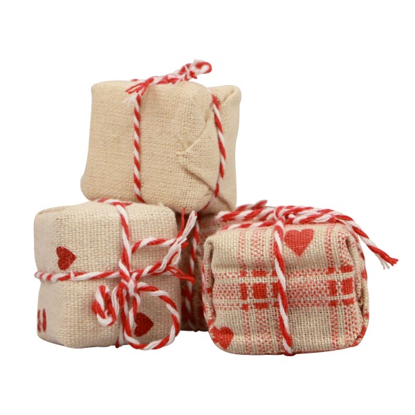 Drei kleine, in Stoff gehüllte und mit einer Schnur verzierte Geschenke mit Herzmotiven