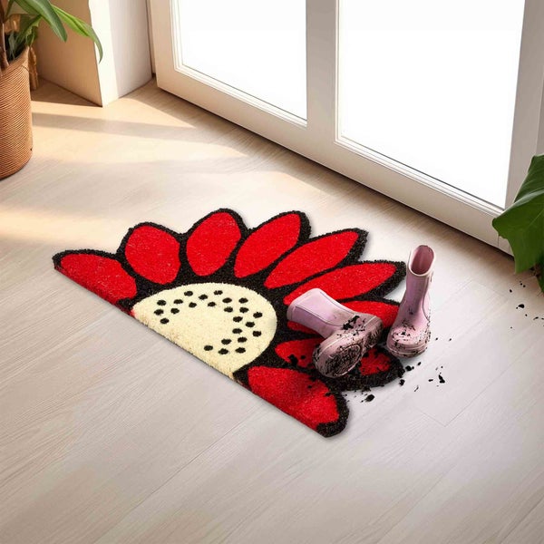 Fußmatte im Blumendesign mit Gummistiefeln vor einer Tür