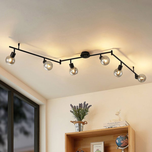 Schwarze Deckenleuchte mit sechs Glaskugeln im Wohnraum.