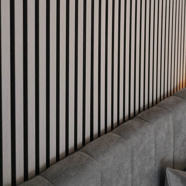 Wand mit Holzlatten Design Tapete hinter einem gepolsterten Bettkopfteil
