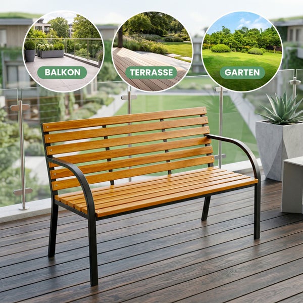 Mann sitzt auf einer Gartenbank aus Holz mit schwarzem Metallgestell auf einer Terrasse und liest ein Buch in einem Garten.