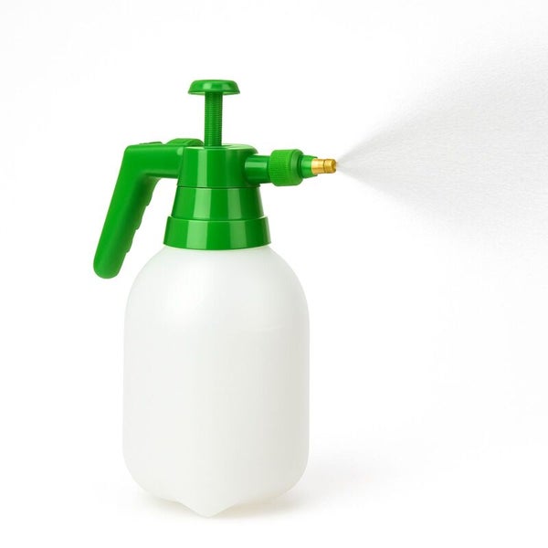 Drucksprüher mit weißem Behälter, grünem Pumpkopf und Messingdüse, versprüht einen feinen Nebel.